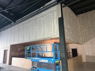 Tall partitions taped and jointed with scissor lift access